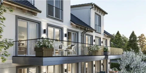 Das Bild zeigt einen architektonisch modernen Balkon eines Mehrfamilienhauses. Zu sehen sind Glasgeländer und blumengeschmückte Möbel. Der Balkon gehört zu einem Gebäude mit blauen Dächern und hellen Fassaden, typisch für Obermenzing.