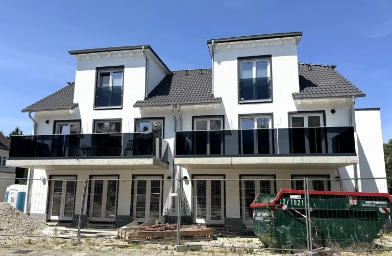 Neubau einer Doppelhaushälfte mit Balkonen, Garten im Bauzustand.