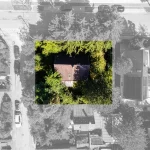 Luftbild zeigt ein von Bäumen umgebenes Haus in Obersendling. Markante Teile sind farbig. Straße mit parkenden Autos rechts.